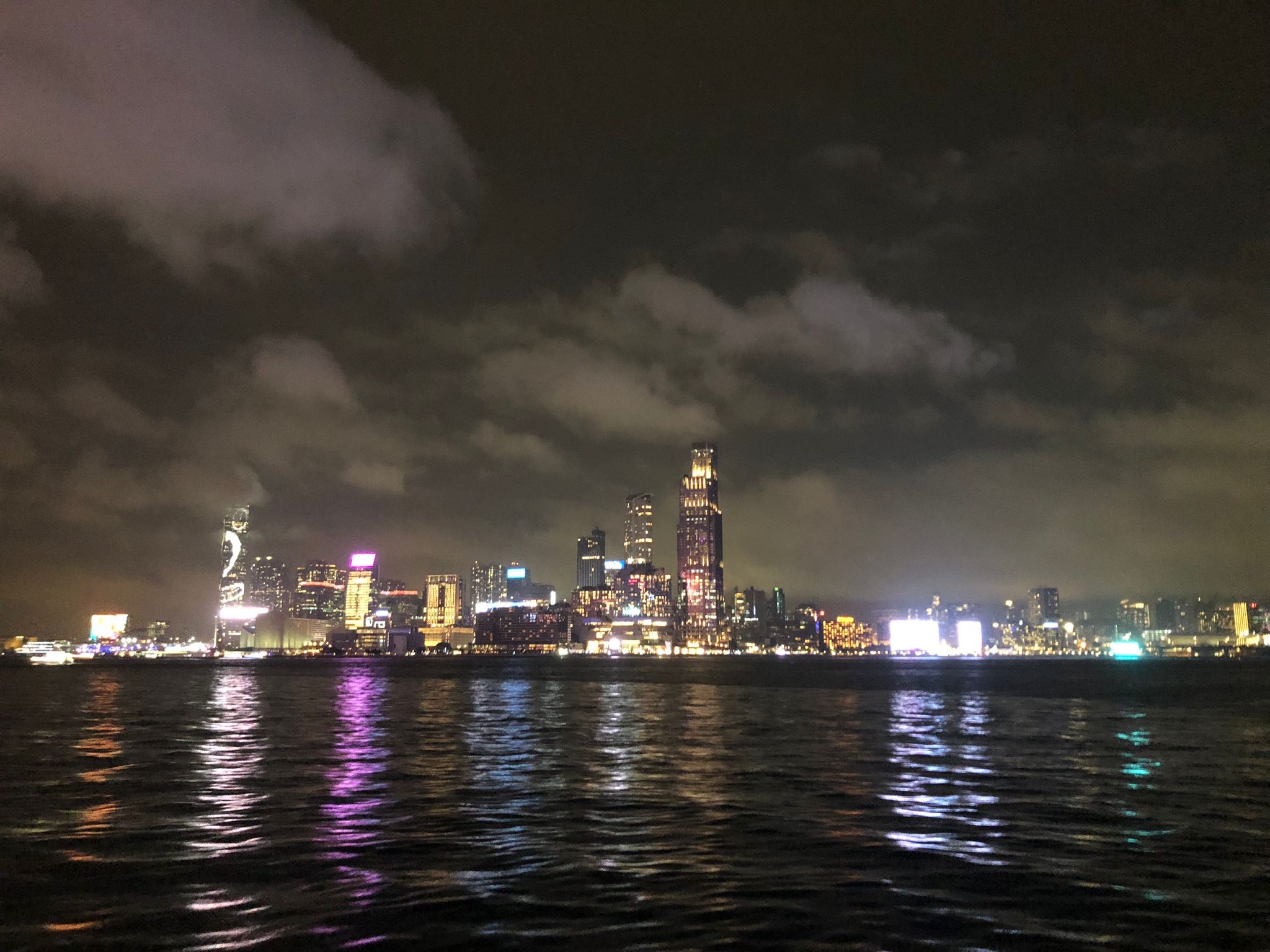 view of Kowloon from Causeway bay at night, raining with hovering clouds.